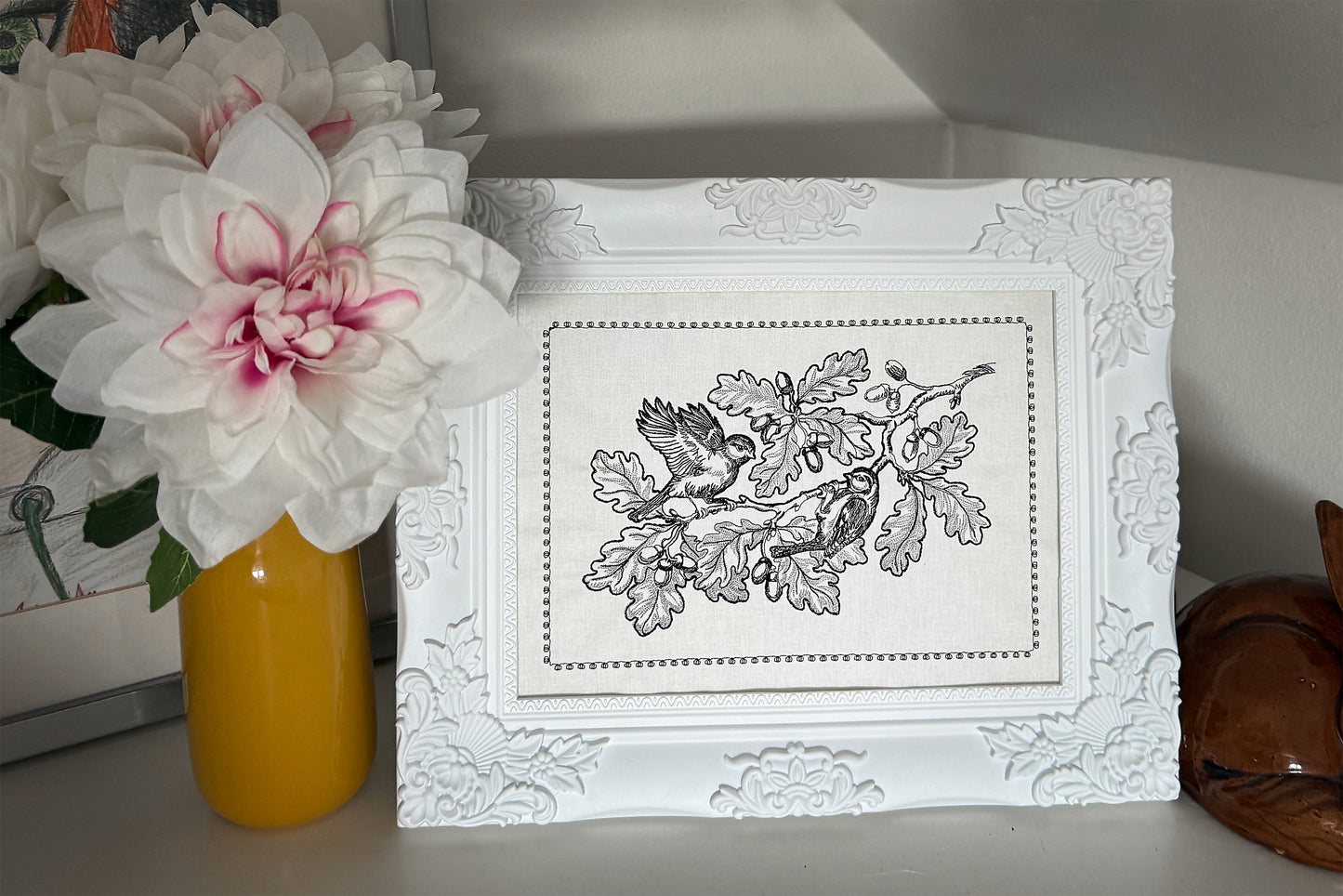 Black and gray machine embroidery featuring birds and acorns