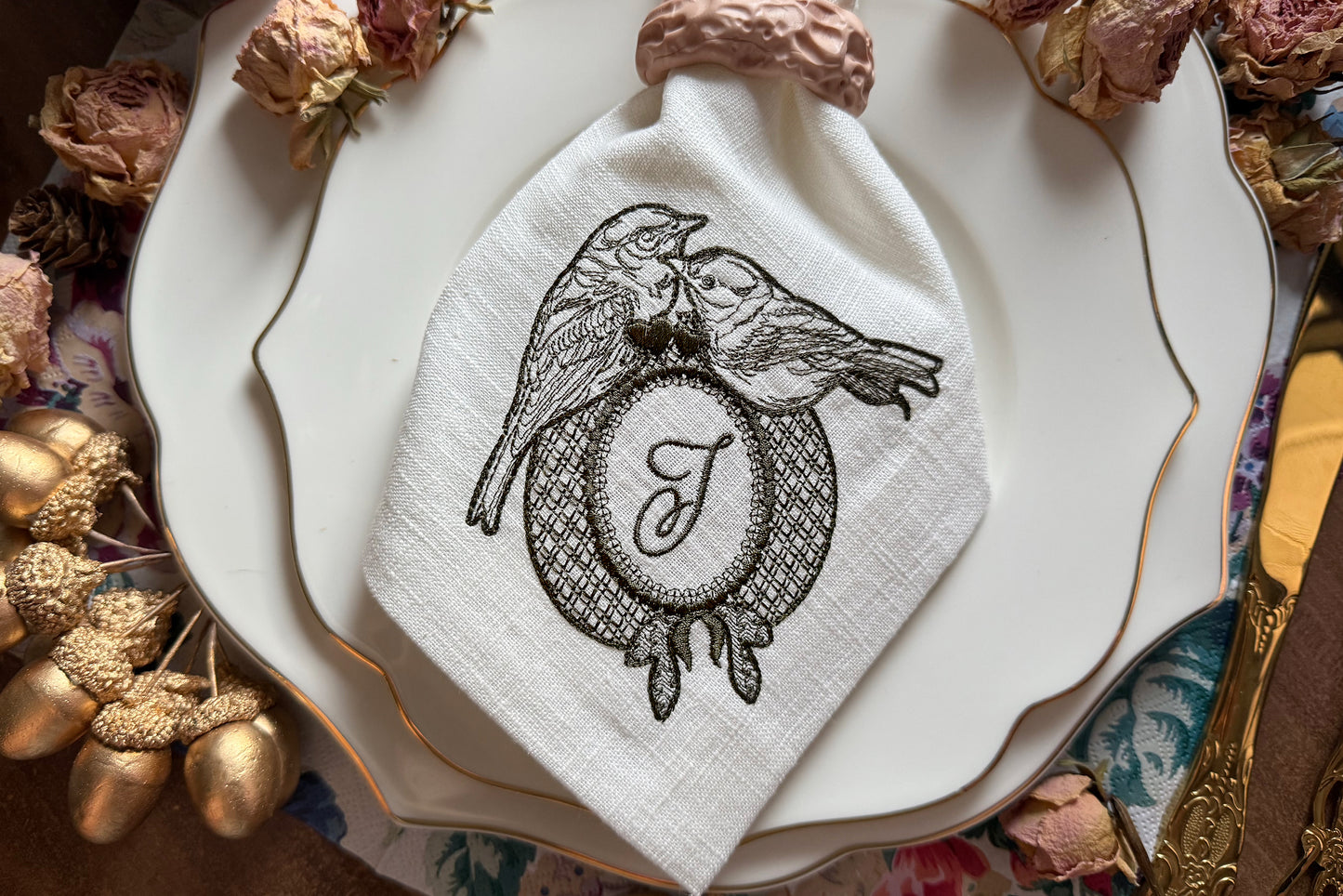 Two birds sitting on an oval embroidery frame with hearts