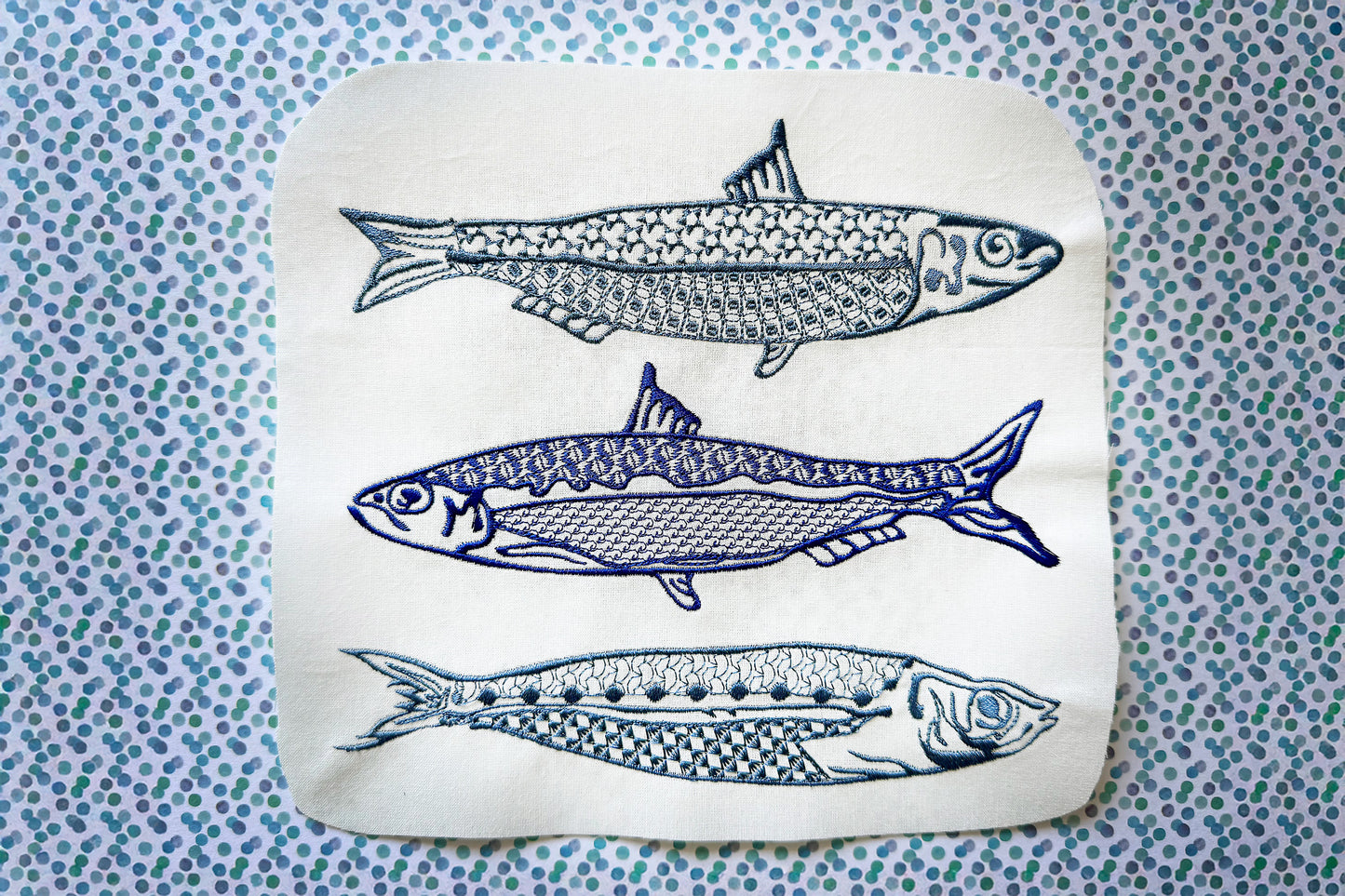 Machine embroidery design with three modern sardines in blue thread