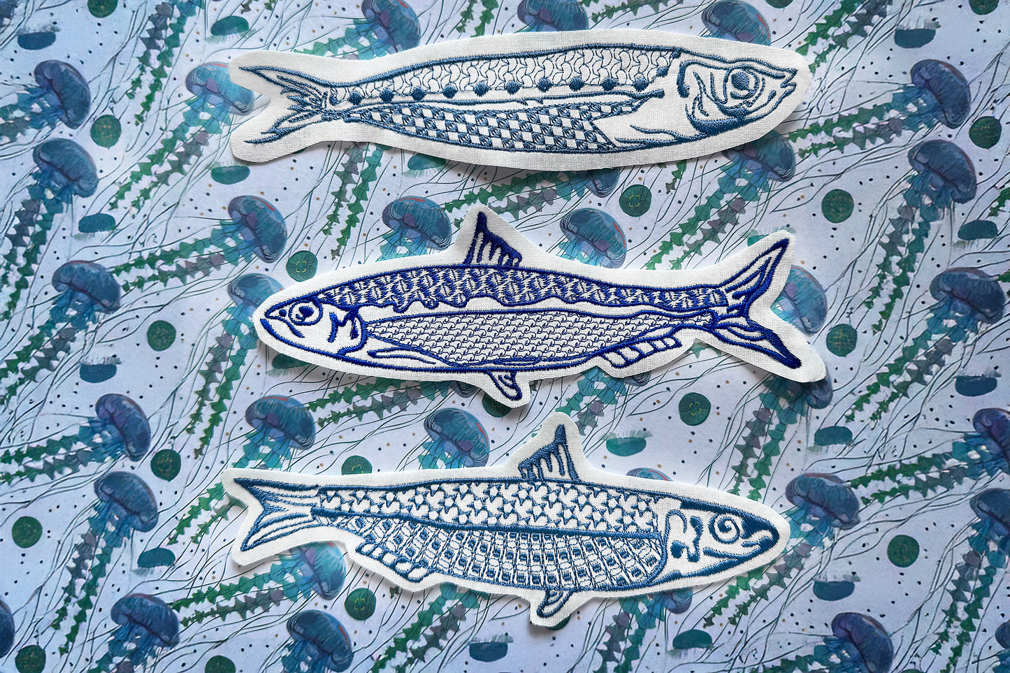 Machine embroidery design with three modern sardines in blue thread