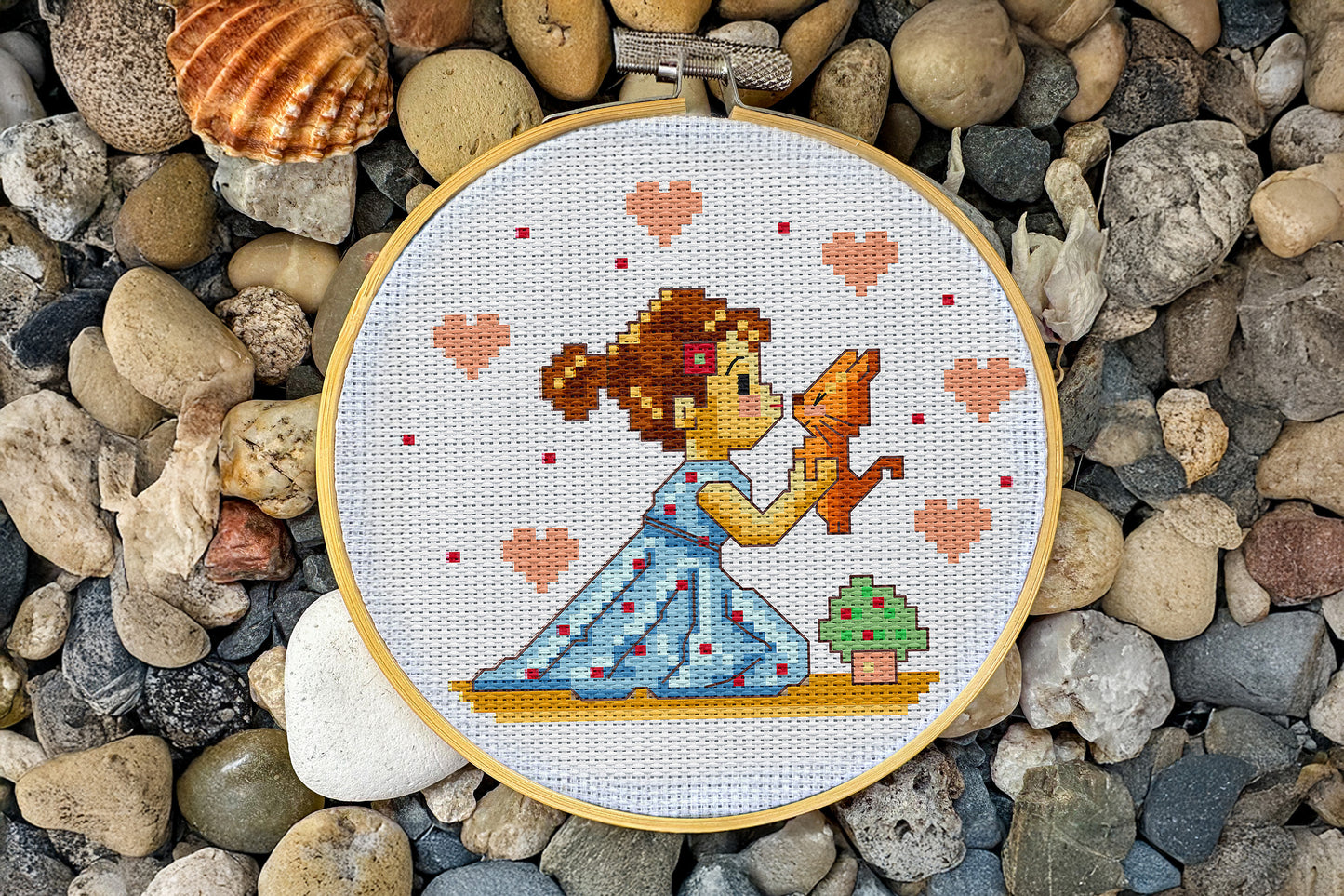 Embroidery design showing a girl kissing a cat, surrounded by hearts, PDF chart