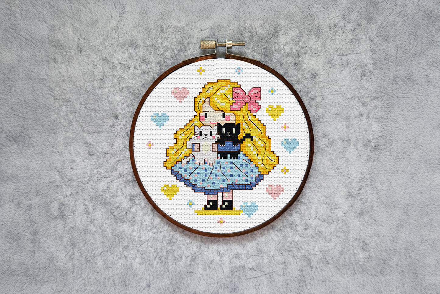 Digital embroidery pattern featuring a girl with a bow holding two kittens.