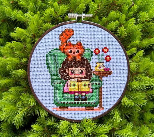 Cute girl in chair with book PDF cross stitch pattern
