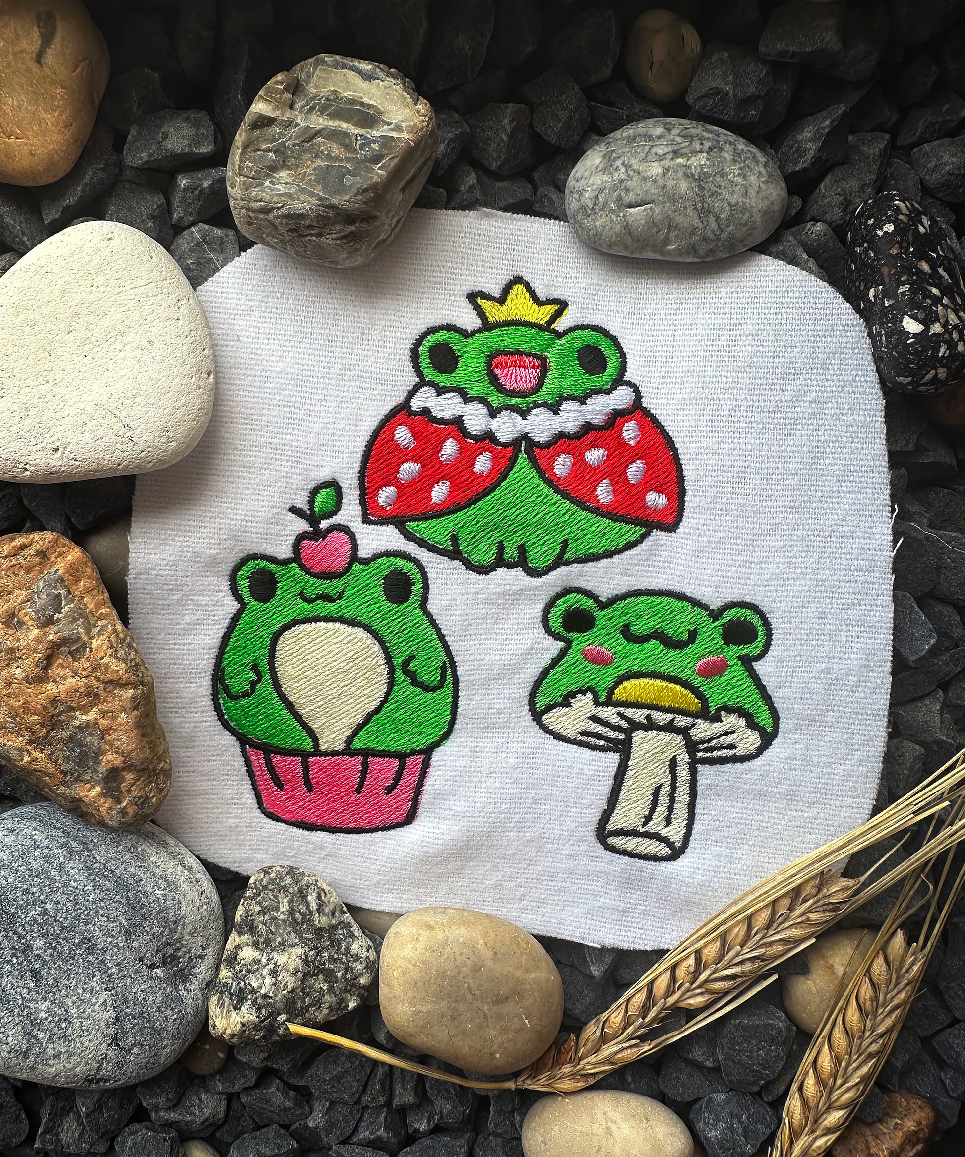Frog embroidery with royal red cloak and crown, stitched on white fabric