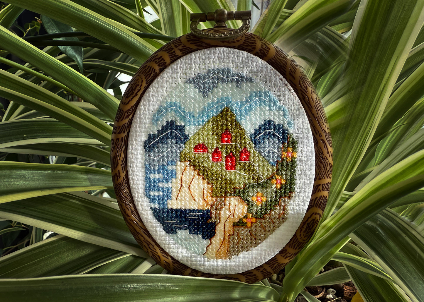 Nordic spring cross-stitch design featuring fjord and green hills