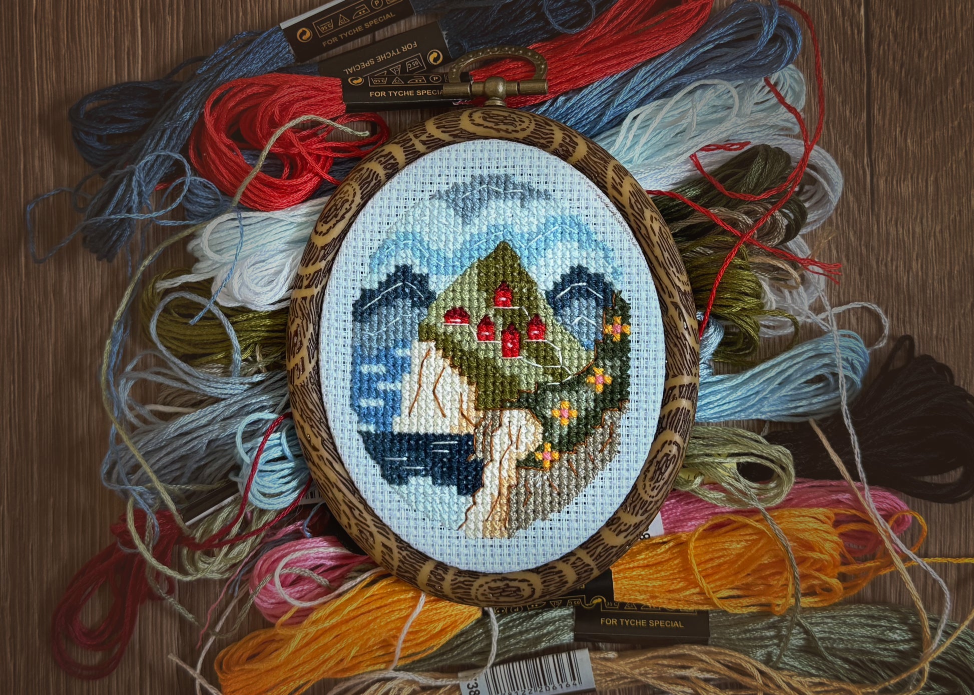 Nordic spring cross-stitch design featuring fjord and green hills