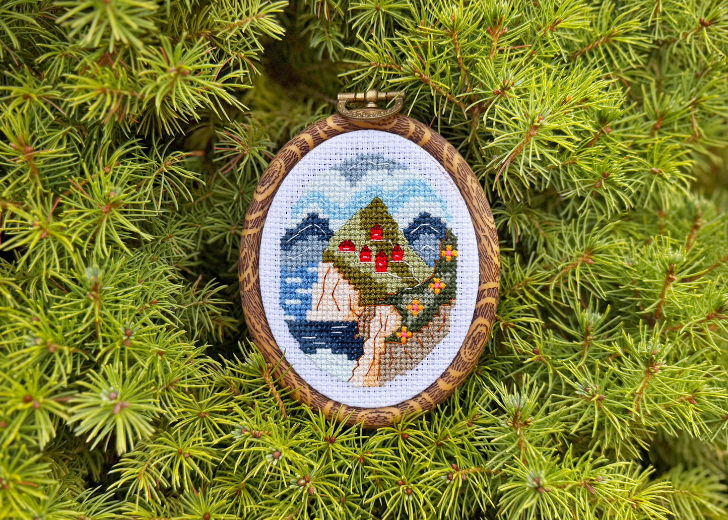 Norwegian fjord cross-stitch art with red houses and blue sea
