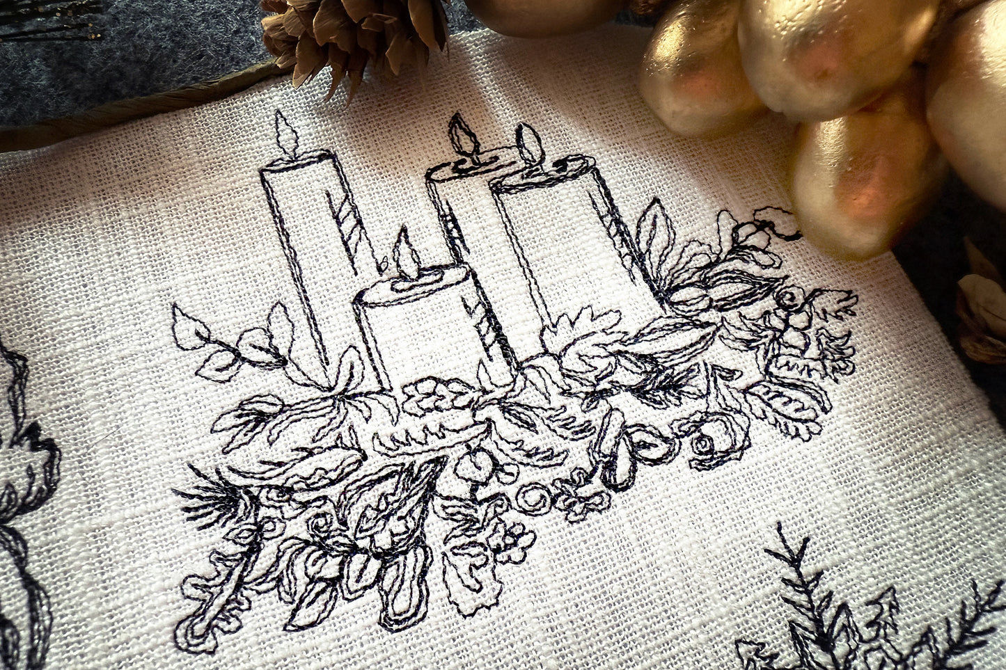 Embroidery design of candles and foliage on fabric with gold accents.