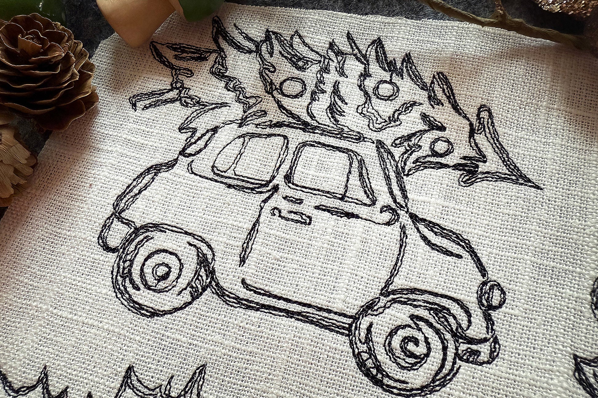 Embroidery design of a car with flames on a fabric background