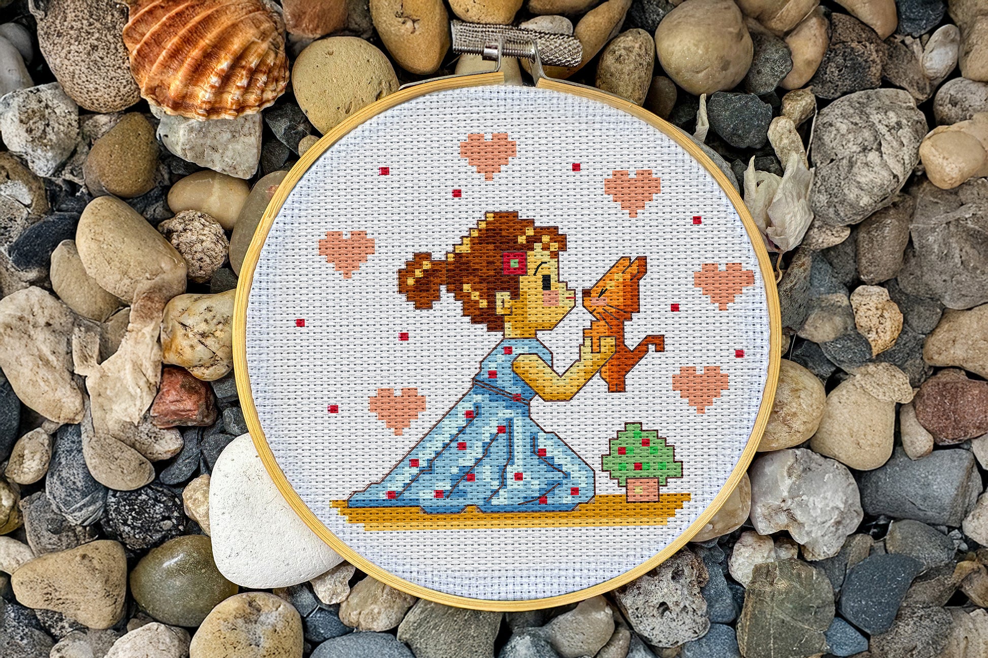 Embroidery design showing a girl kissing a cat, surrounded by hearts, PDF chart