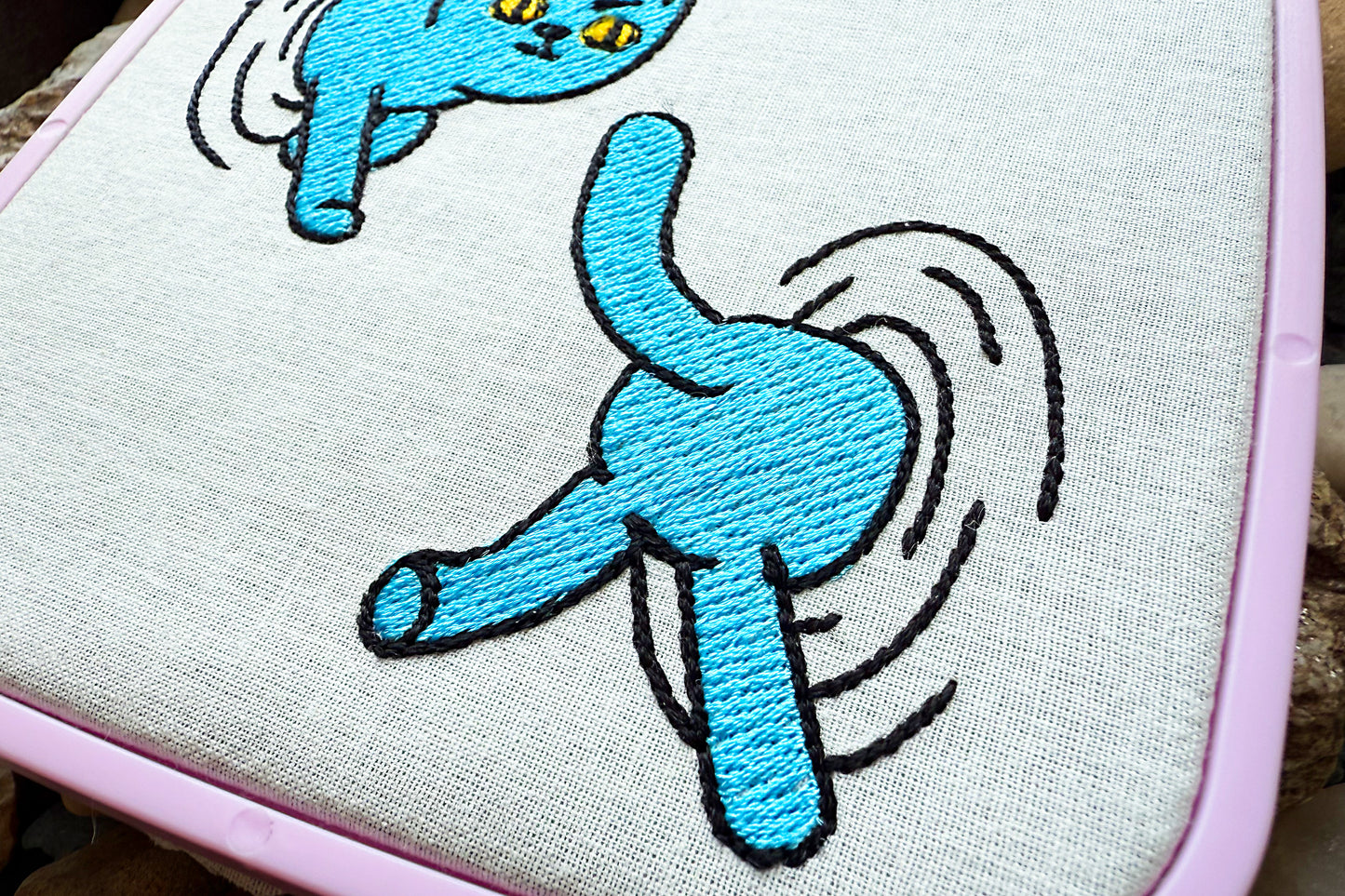 Playful machine stitch design featuring a cat jumping through portals