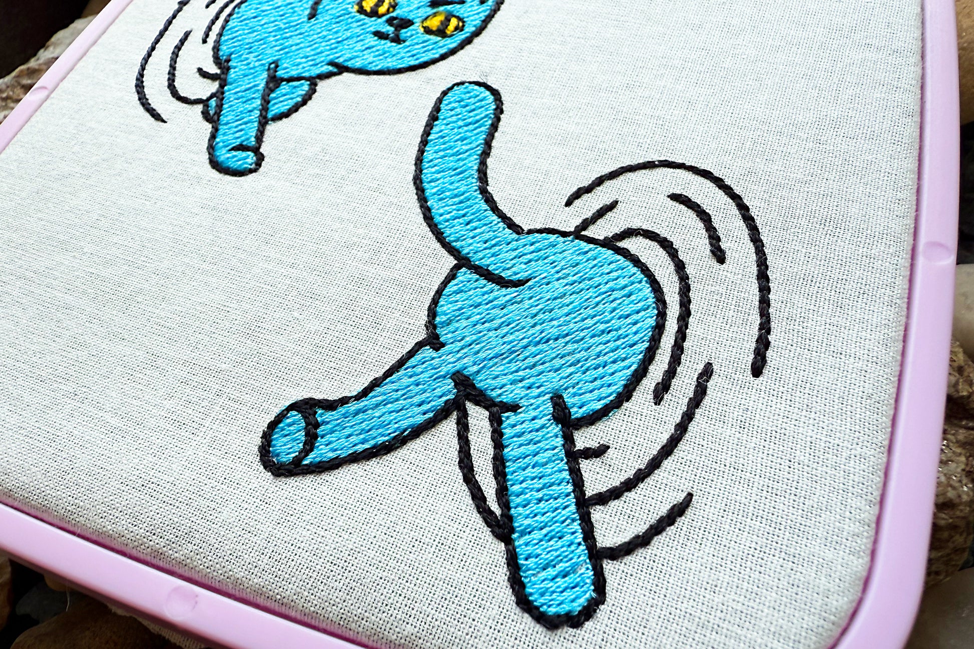 Playful machine stitch design featuring a cat jumping through portals