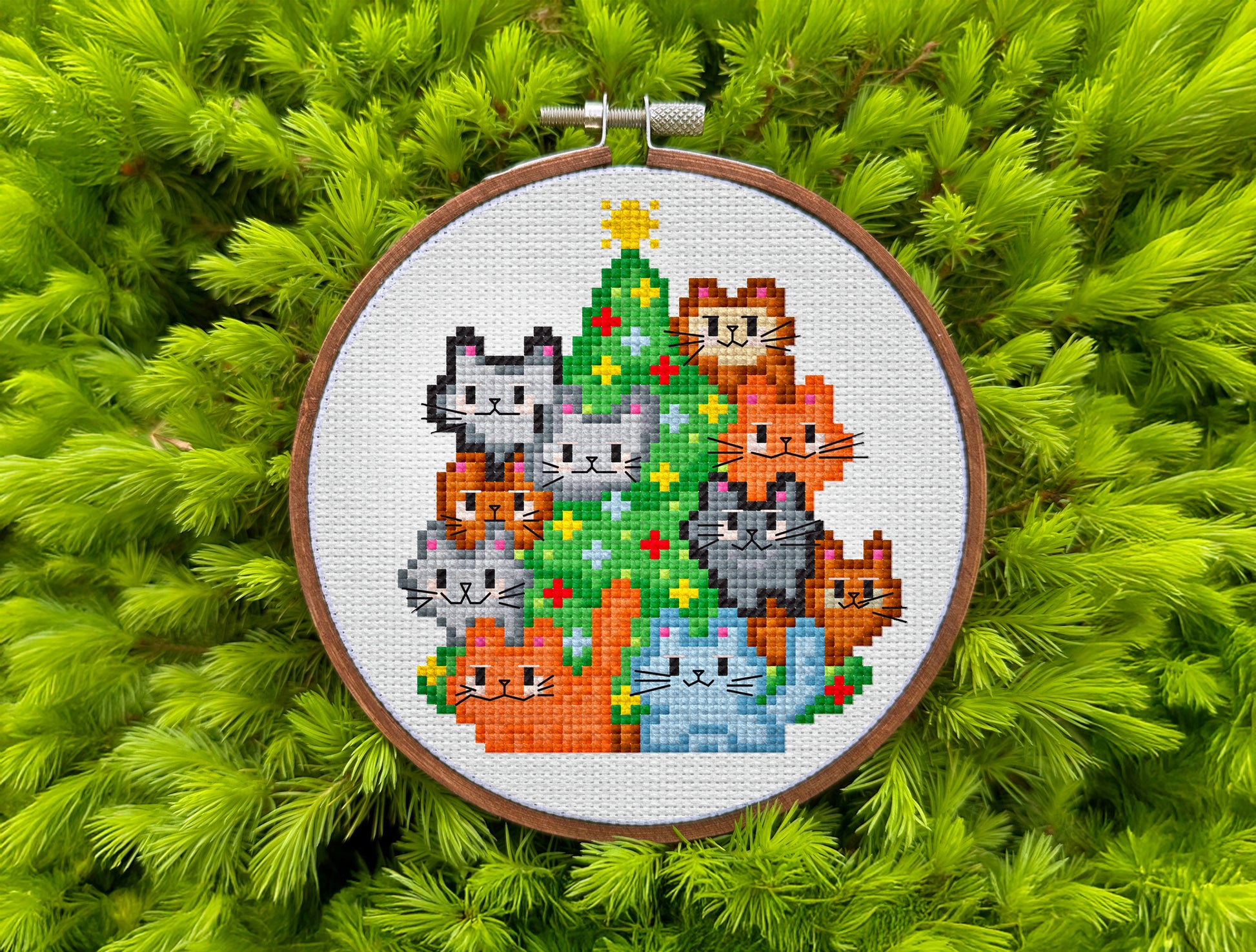 Playful festive cross-stitch pattern featuring colorful cats and ornaments