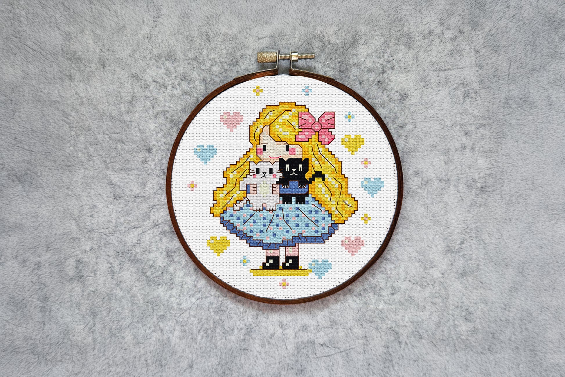 Digital embroidery pattern featuring a girl with a bow holding two kittens.