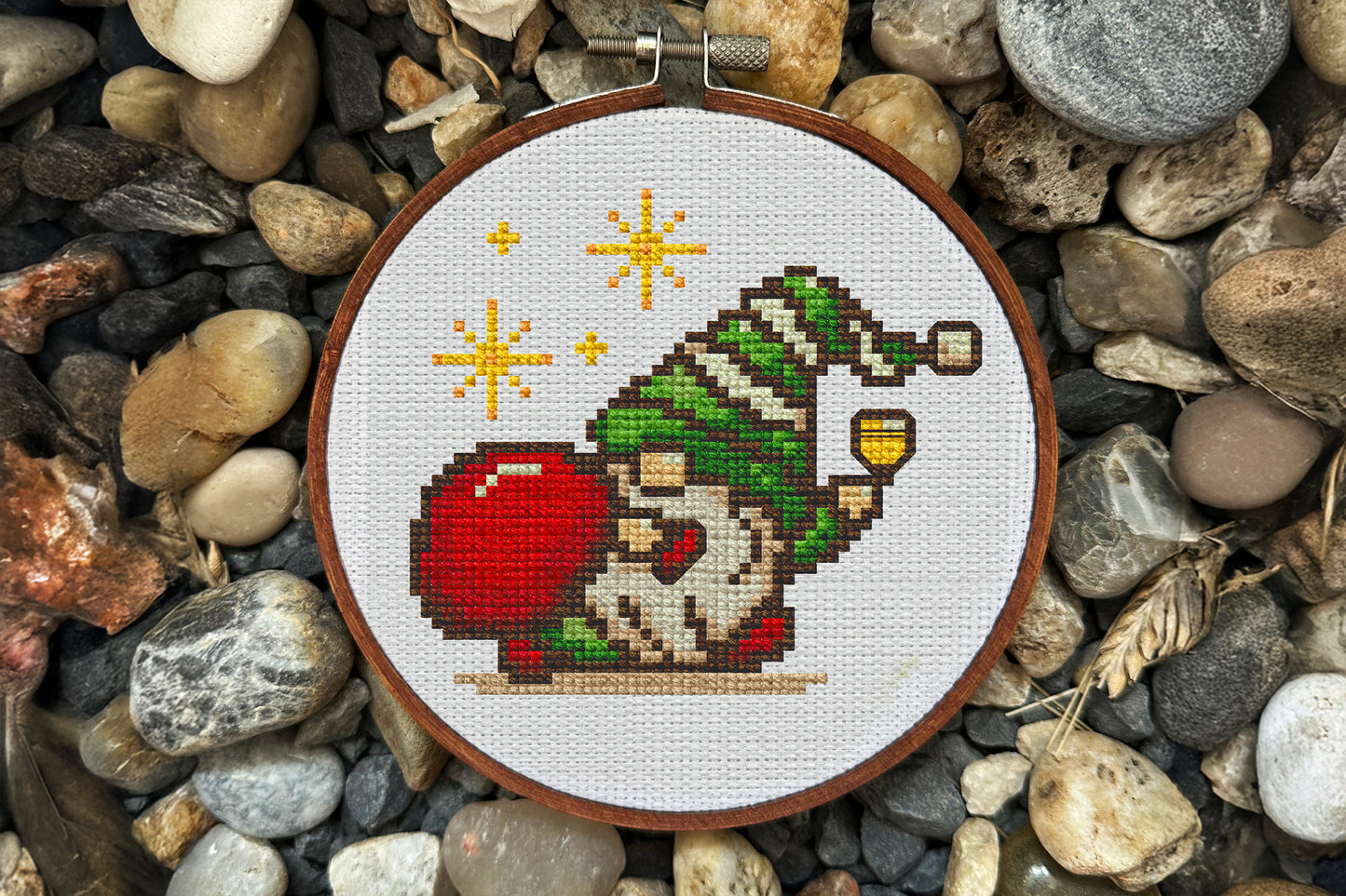 Cross-stitched design of a gnome surrounded by stones